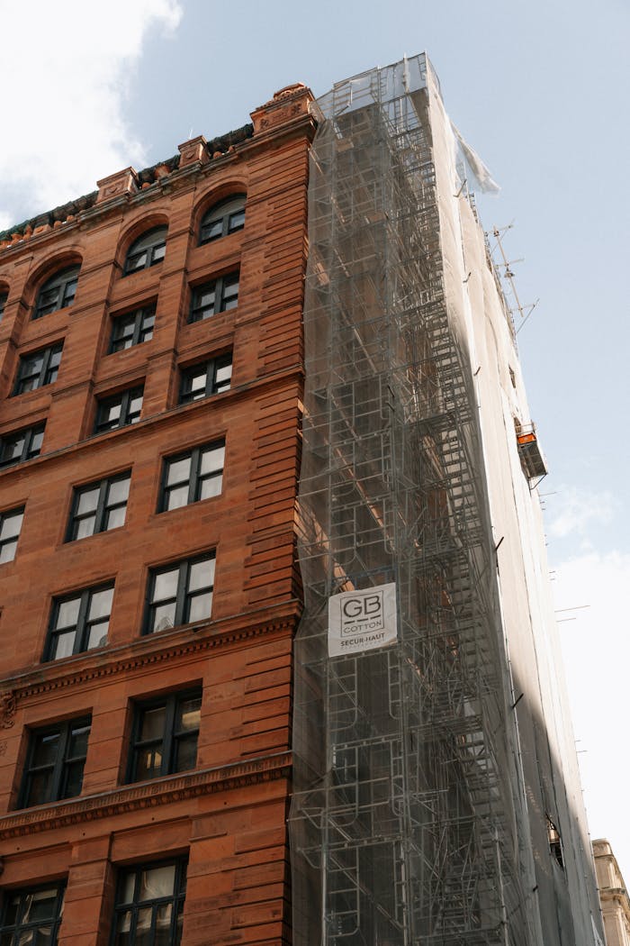 A historic red brick building under renovation with scaffolding in Montreal, Canada.